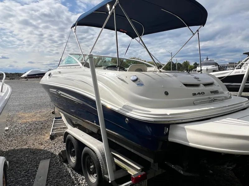 Slide: The Image of 2009 Sea Ray 240 Sundeck boat on trailer with canopy, parked outdoors. - 4