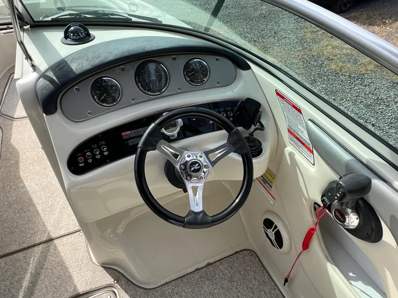 Slide: The Image of 2009 Sea Ray 240 Sundeck dashboard with steering wheel and instrument panel. - 7