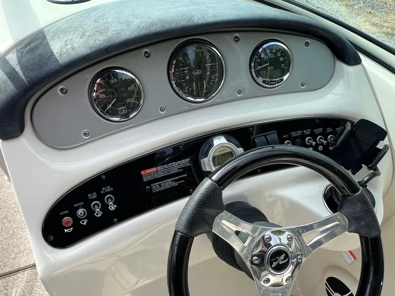 Slide: The Image of 2009 Sea Ray 240 Sundeck dashboard with steering wheel and gauges. - 8