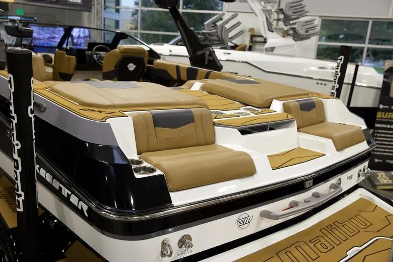 Slide: The Image of 2025 Malibu 22 MXZ luxury boat interior with tan and black seating. - 10
