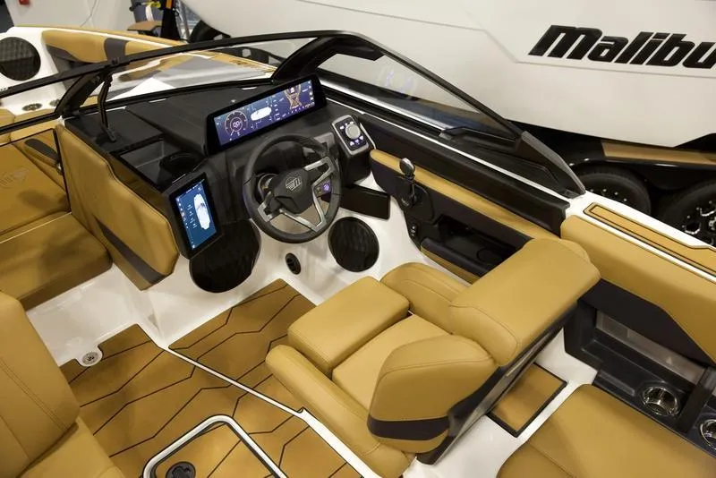 Slide: The Image of Luxurious interior of 2025 Malibu 22 MXZ boat with advanced dashboard and tan seating. - 13