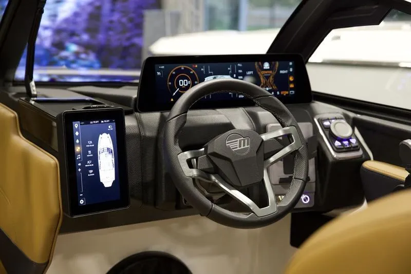 Slide: The Image of 2025 Malibu 22 MXZ dashboard with modern digital displays and steering wheel. - 14