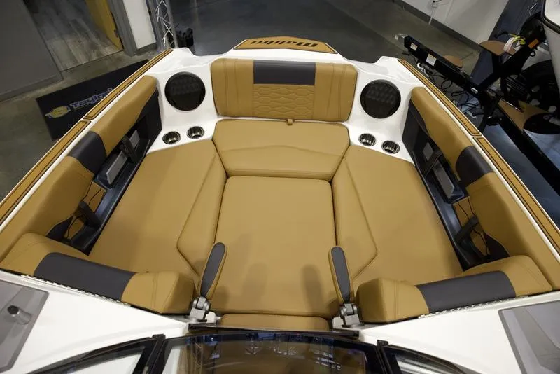 Slide: The Image of 2025 Malibu 22 MXZ boat interior with tan and black seating. - 17