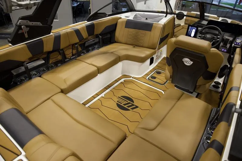 Slide: The Image of Luxurious interior of 2025 Malibu 22 MXZ boat with tan seating and modern dashboard. - 18