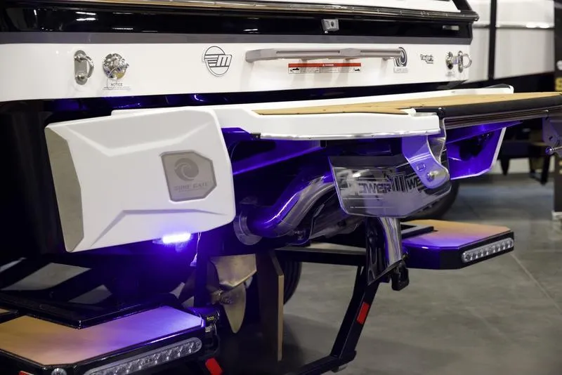 Slide: The Image of 2025 Malibu 22 MXZ boat rear view with illuminated underwater lights. - 5