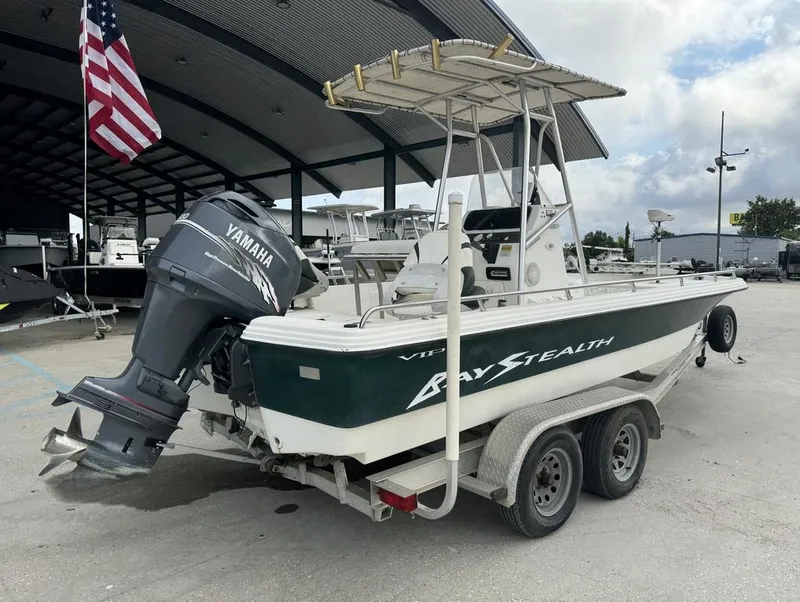 Slide: The Image of 2001 Bay Stealth VIP 2230 boat with Yamaha motor on trailer, parked under a canopy. - 13