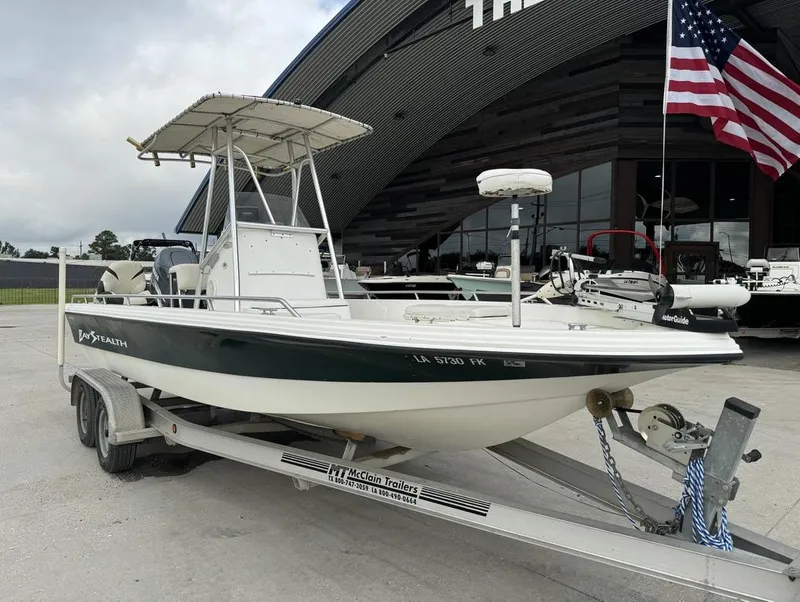 Slide: The Image of 2001 Bay Stealth VIP 2230 boat on trailer, parked outdoors with American flag. - 15