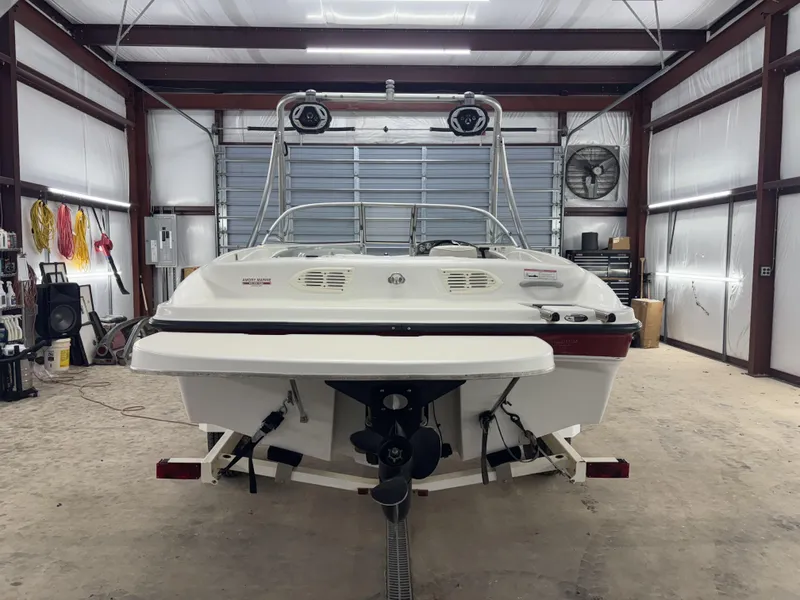 Slide: The Image of 2008 Bayliner Bowrider 185 in a garage, rear view showing engine and interior details. - 13