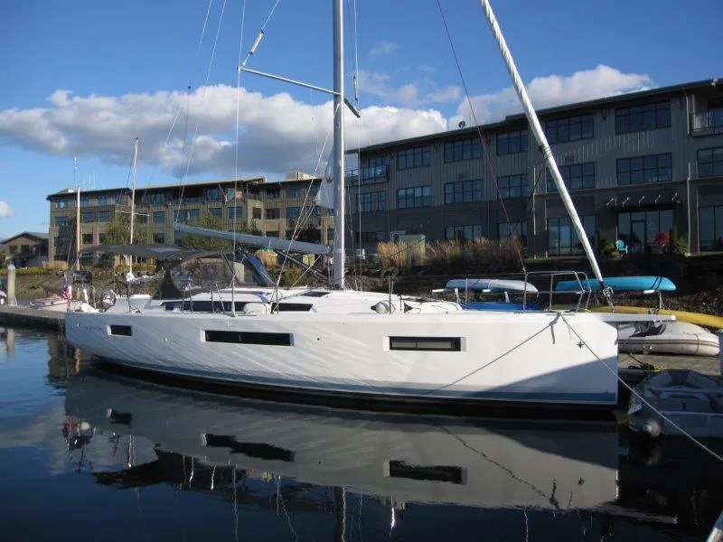 Slide: The Image of 2021 Jeanneau Sun Odyssey 440 sailboat docked near modern buildings. - 34