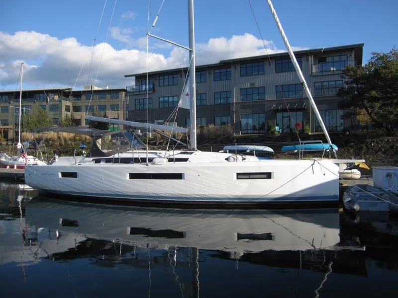 Slide: The Image of 2021 Jeanneau Sun Odyssey 440 sailboat docked near modern buildings. - 35