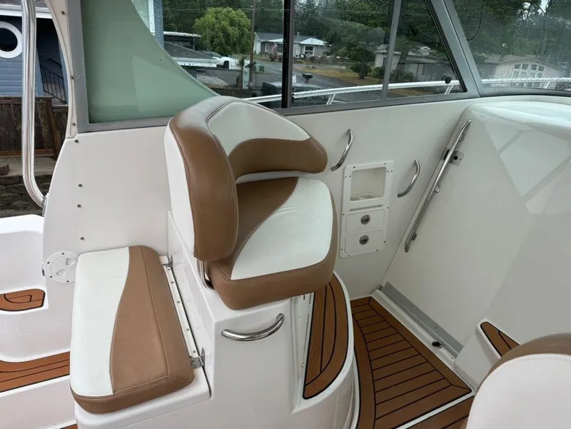 Slide: The Image of 2006 Seaswirl 2901 boat interior with tan and white seating, wood accents, and windows. - 7