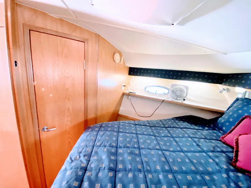 Slide: The Image of Cozy cabin interior of 2001 Tiara Yachts 3800 Open with blue bedding and wooden accents. - 40