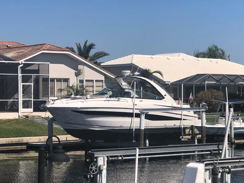 Slide: The Image of 2014 Sea Ray 370 Venture boat docked near waterfront homes. - 0