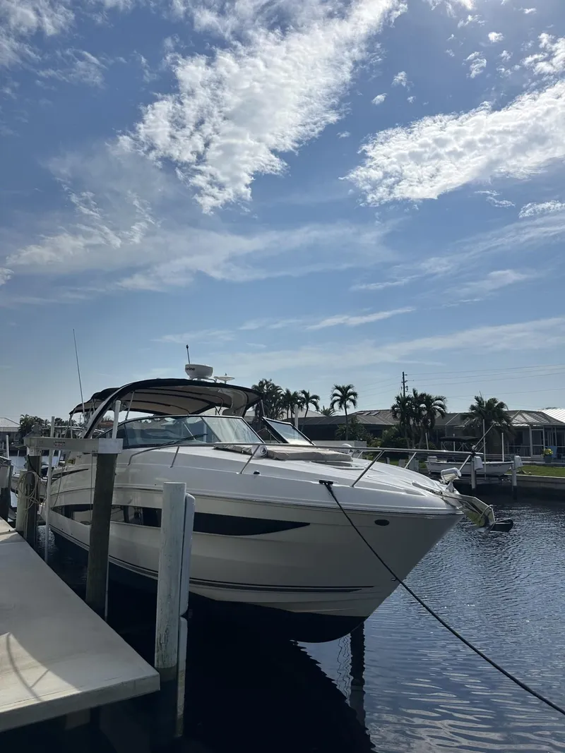 Slide: The Image of 2014 Sea Ray 370 Venture docked under a partly cloudy sky. - 1