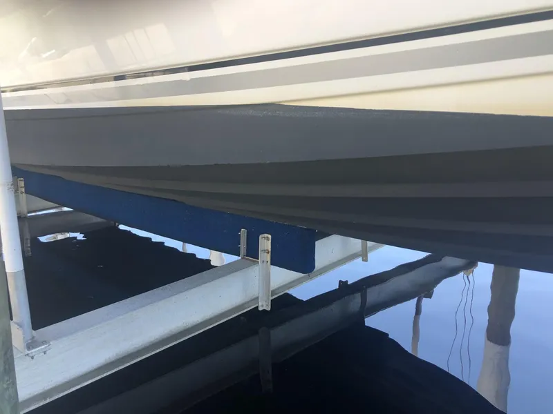 Slide: The Image of 2014 Sea Ray 370 Venture boat hull on a lift, reflecting in calm water. - 11