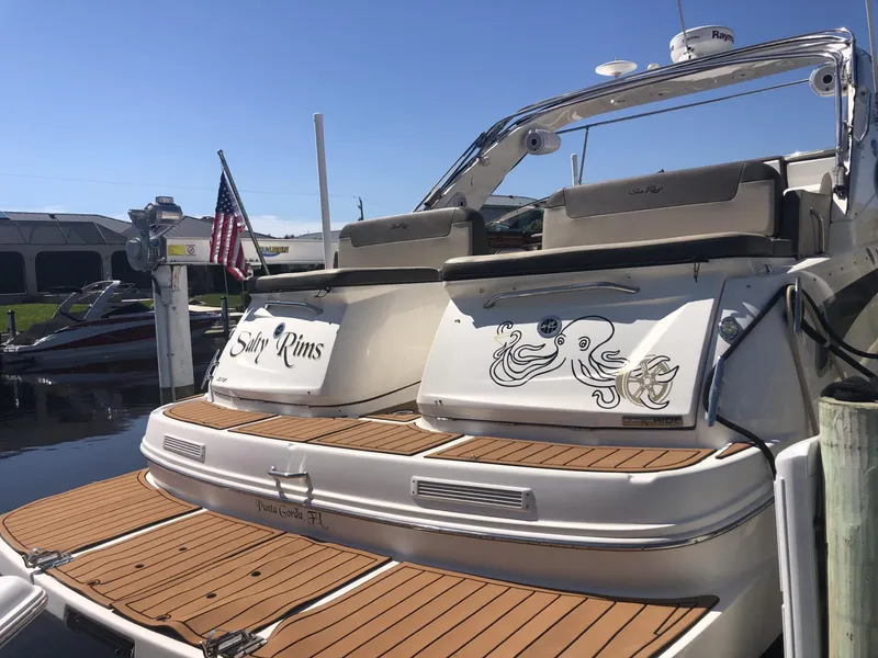 Slide: The Image of 2014 Sea Ray 370 Venture boat docked with custom graphics and American flag. - 12