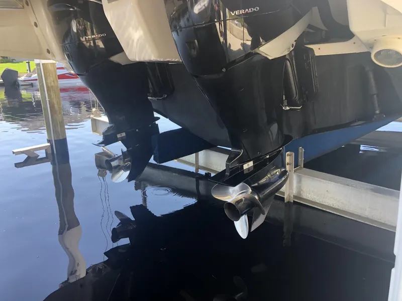 Slide: The Image of 2014 Sea Ray 370 Venture outboard motors on a lift, reflecting in water. - 14
