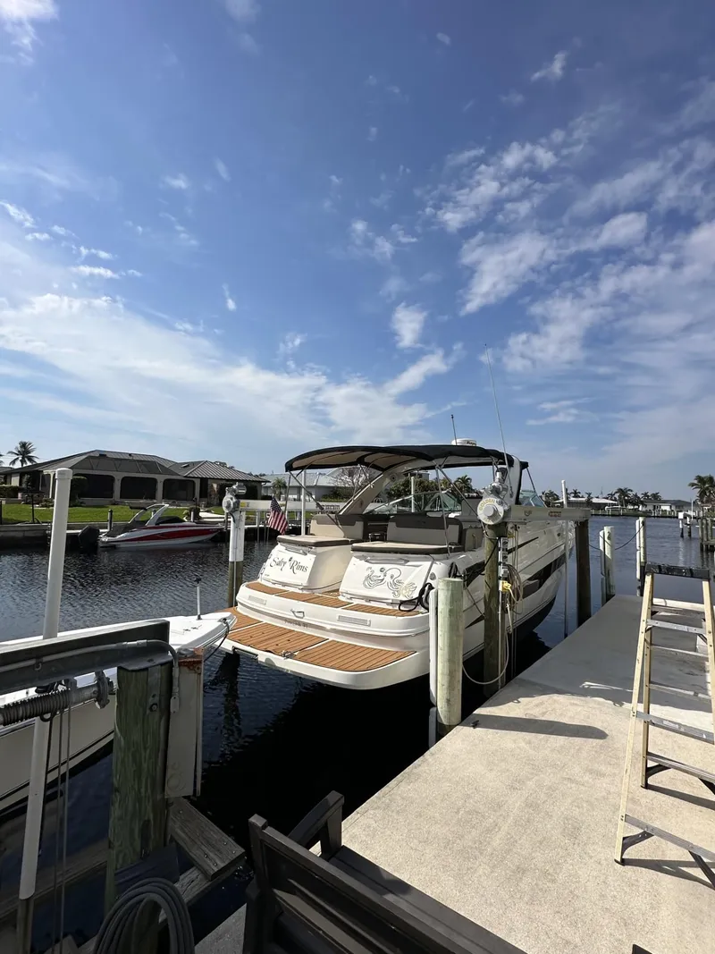 Slide: The Image of 2014 Sea Ray 370 Venture docked under a clear blue sky. - 3