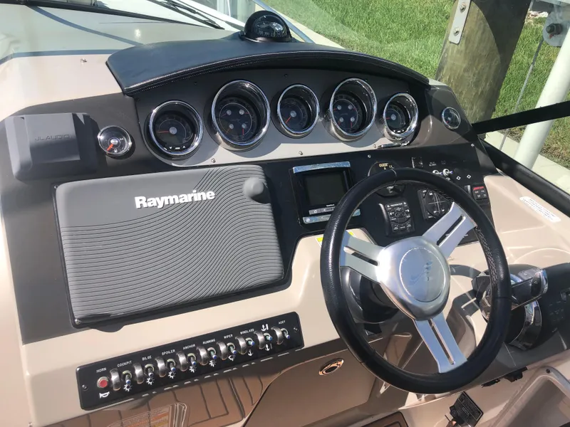 Slide: The Image of 2014 Sea Ray 370 Venture dashboard with Raymarine navigation system and gauges. - 33