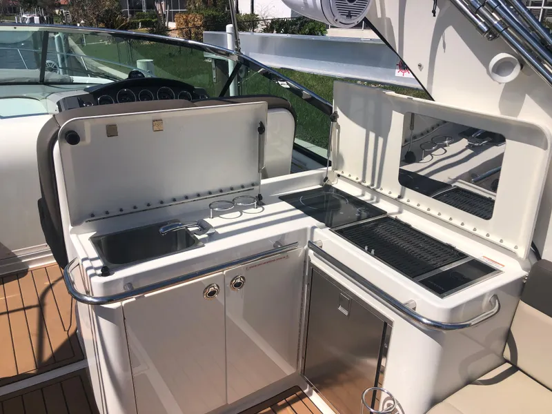 Slide: The Image of 2014 Sea Ray 370 Venture boat kitchen with sink, grill, and storage. - 47