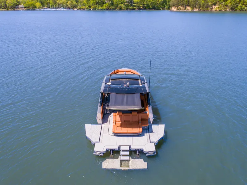 Slide: The Image of 2023 Cruisers Yachts 42 GLS on serene lake with lush green shoreline. - 1