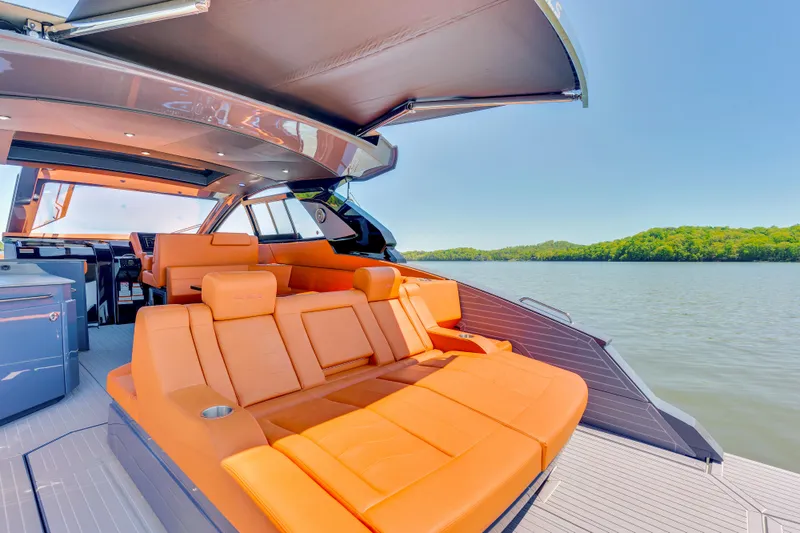 Slide: The Image of 2023 Cruisers Yachts 42 GLS with luxurious orange seating on a serene lake. - 14