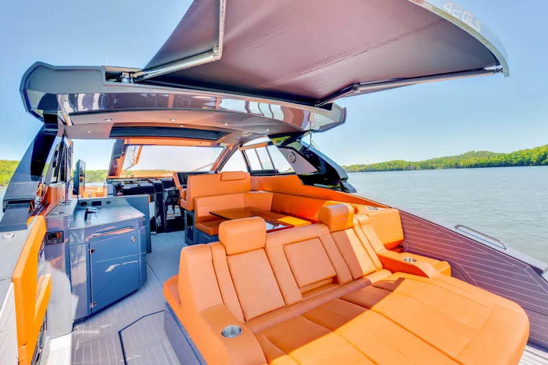 Slide: The Image of 2023 Cruisers Yachts 42 GLS with luxurious orange seating and sleek design on a serene lake. - 15