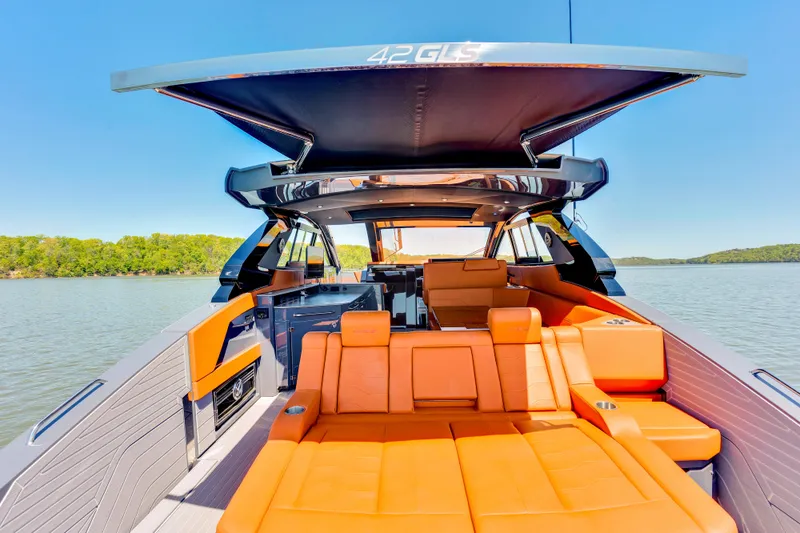 Slide: The Image of 2023 Cruisers Yachts 42 GLS with luxurious orange seating on a serene lake. - 16