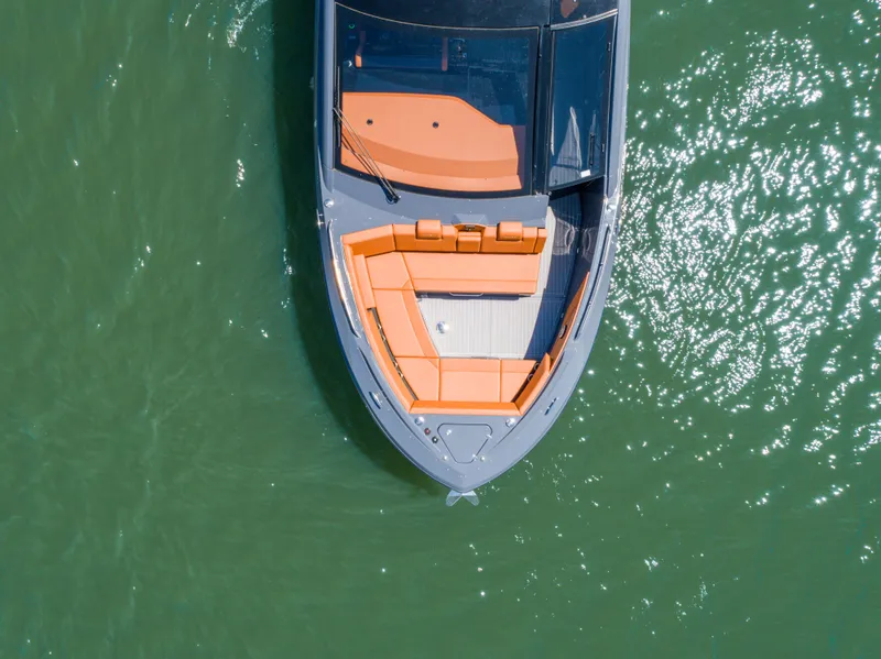 Slide: The Image of 2023 Cruisers Yachts 42 GLS, aerial view, sleek design, orange seating, on shimmering water. - 3