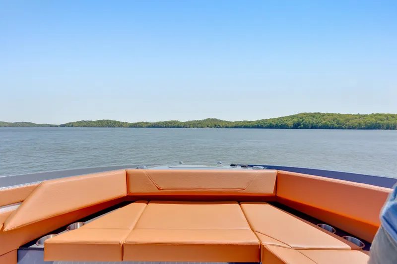 Slide: The Image of 2023 Cruisers Yachts 42 GLS with tan seating, overlooking serene lake and forested shoreline. - 30