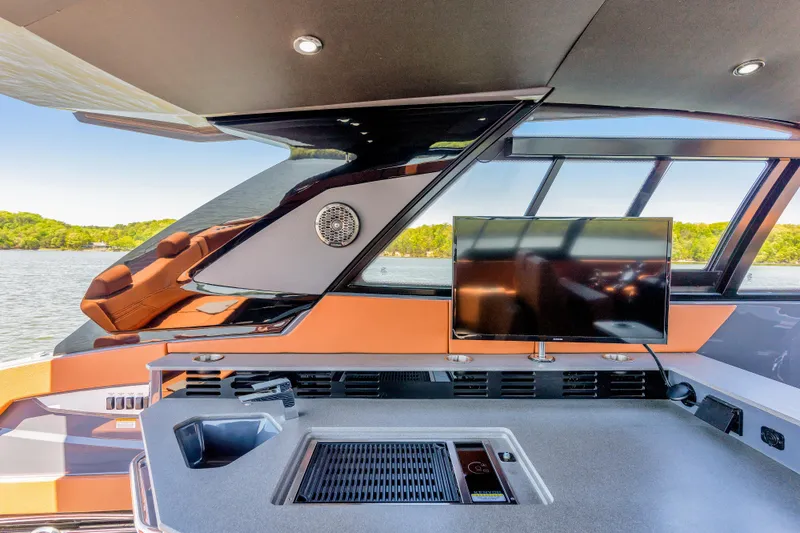 Slide: The Image of 2023 Cruisers Yachts 42 GLS interior with TV and modern amenities, overlooking serene waters. - 32