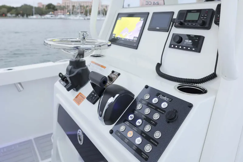 Slide: The Image of 2025 Parker 2400 Center Console boat interior with seating and motor, displayed on red carpet. - 4