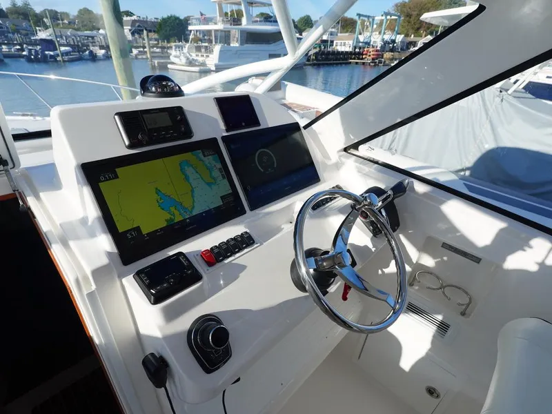 Slide: The Image of 2024 Albemarle 30 Express helm with navigation screens and steering wheel. - 10