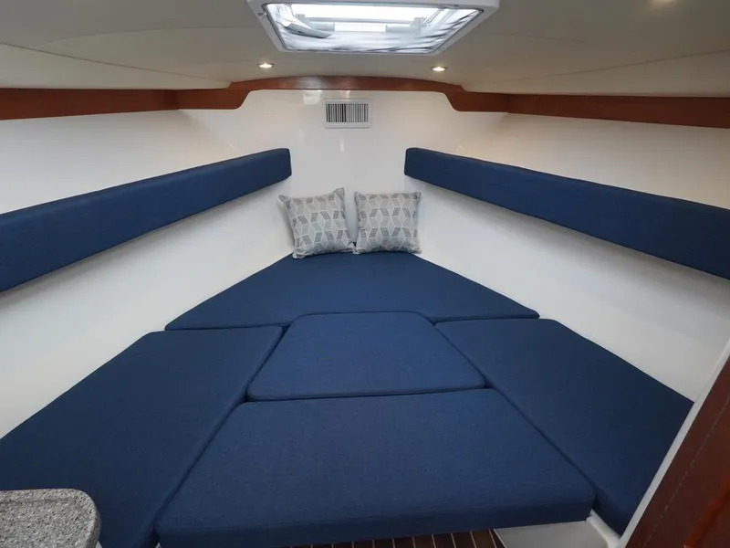 Slide: The Image of 2024 Albemarle 30 Express cabin interior with blue cushions and pillows. - 7