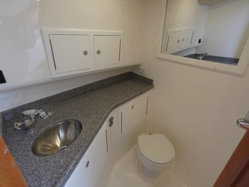 Slide: The Image of 2024 Albemarle 30 Express boat bathroom with sink, toilet, and storage cabinets. - 8