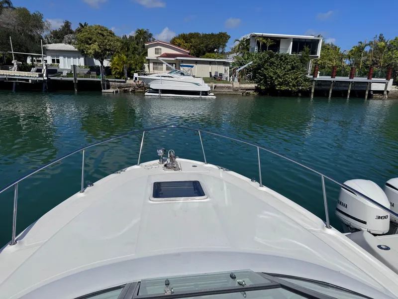 Slide: The Image of 2004 Sea Ray 290 Amberjack cruising in a serene waterfront setting. - 12