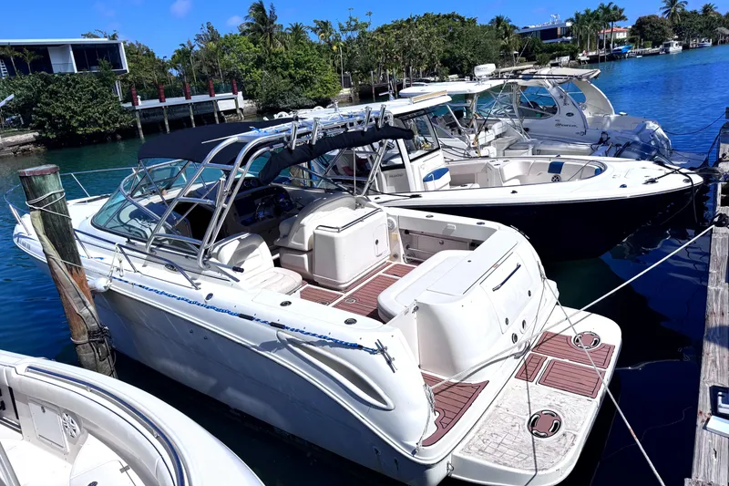 Slide: The Image of 2004 Sea Ray 290 Amberjack docked in a sunny marina, surrounded by other boats. - 15