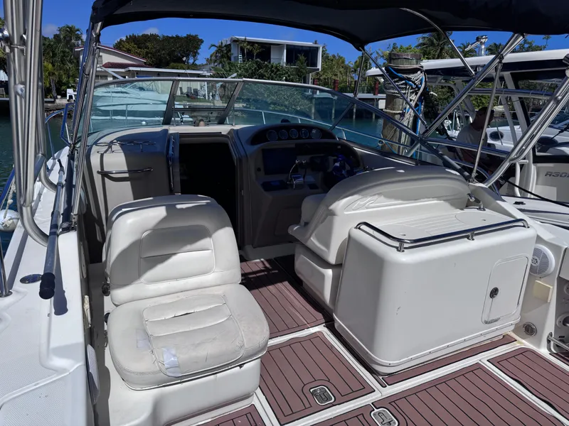 Slide: The Image of 2004 Sea Ray 290 Amberjack boat interior with seating and helm, docked in a marina. - 7