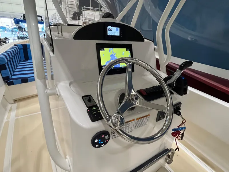 Slide: The Image of 2021 Vanquish 26 boat helm with steering wheel and navigation display. - 12