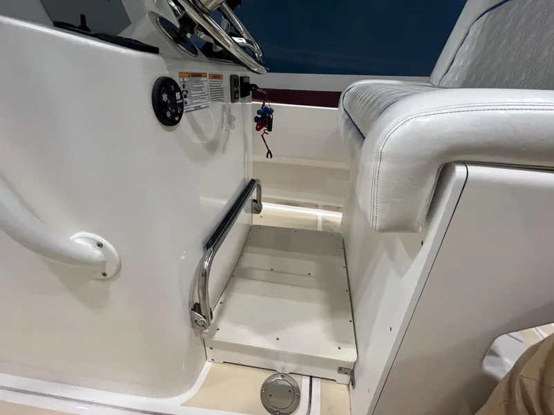 Slide: The Image of Interior of 2021 Vanquish 26 boat, featuring white seating and control panel. - 13