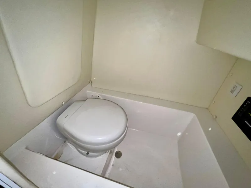 Slide: The Image of Compact bathroom in 2021 Vanquish 26 boat with white toilet. - 16