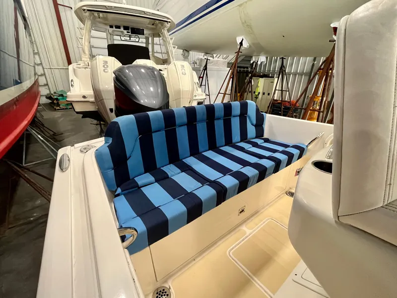 Slide: The Image of 2021 Vanquish 26 boat with blue striped seating in storage. - 17