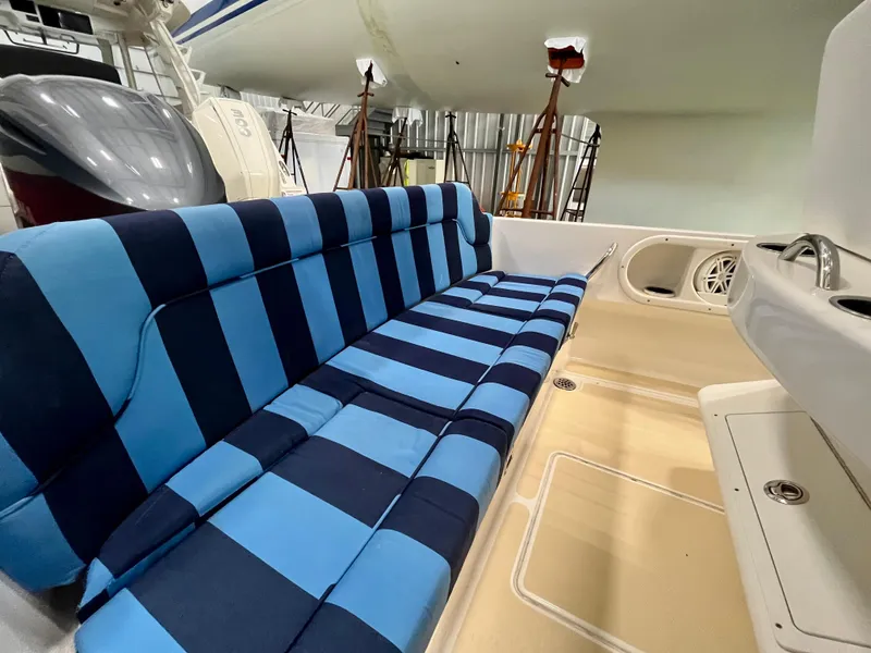 Slide: The Image of Blue and black striped seating on 2021 Vanquish 26 boat interior. - 18