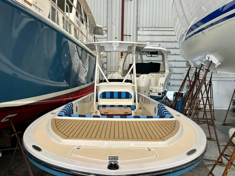 Slide: The Image of 2021 Vanquish 26 boat in storage, featuring sleek design and spacious deck. - 22