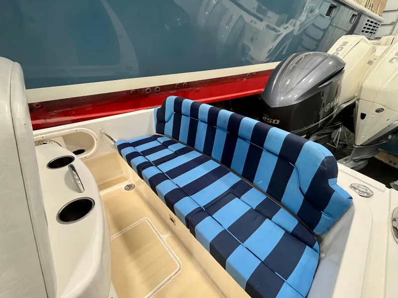 Slide: The Image of Vanquish 26 boat interior with blue striped seating, 2021 model, featuring dual outboard motors. - 4