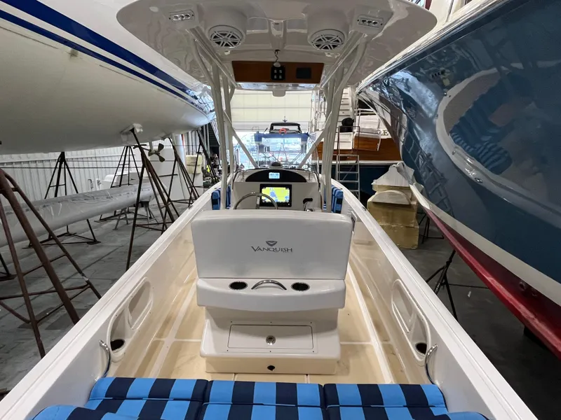 Slide: The Image of 2021 Vanquish 26 boat interior in storage, featuring seating and console. - 6