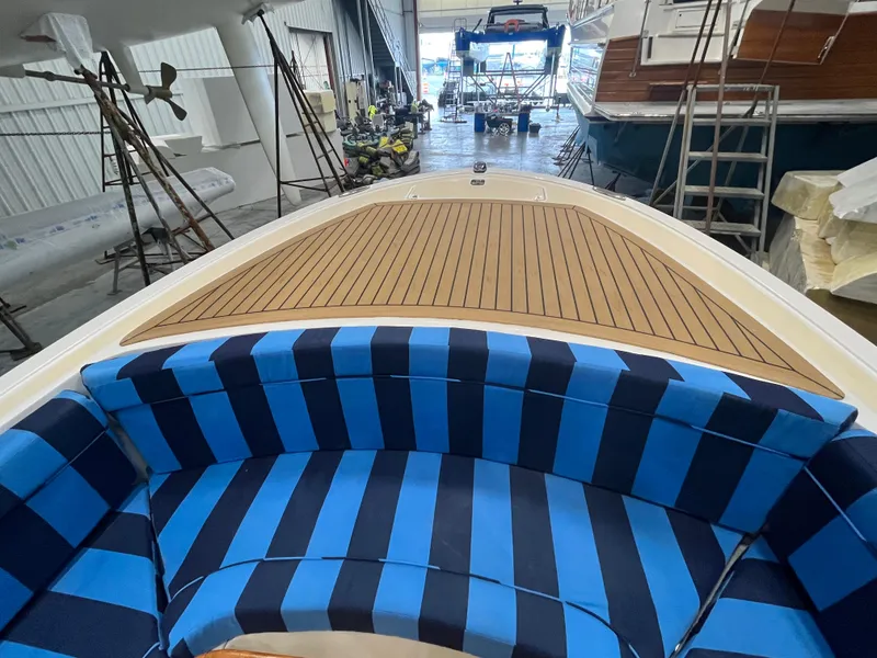 Slide: The Image of Vanquish 26 boat interior with striped seating, 2021 model in a storage facility. - 7