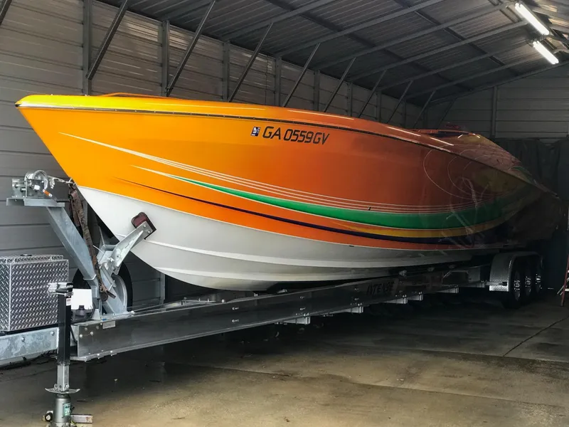 Slide: The Image of 2005 Outerlimits 51 Sport Yacht in vibrant orange, stored indoors on a trailer. - 7