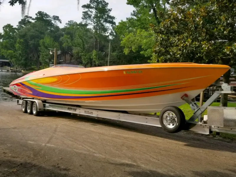 Slide: The Image of 2005 Outerlimits 51 Sport Yacht with vibrant orange and green design on a trailer. - 8