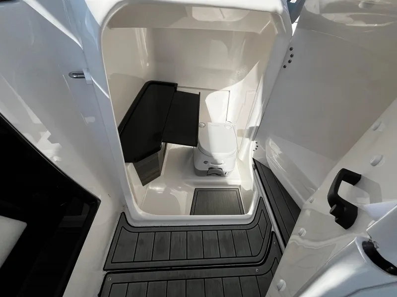 Slide: The Image of 2023 Yamaha Boats 275 SDX interior cabin with compact toilet and seating. - 13